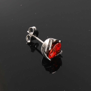 Macro view of vintage silver stud earring with ruby red marquise-cut stone and butterfly clasp