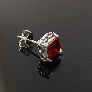 Detailansicht eines quadratischen roten Zirkonohrrings mit silbernem Kettenmuster