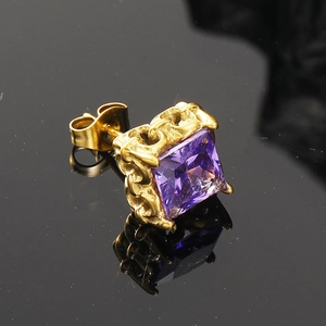 Dettaglio macro dell'orecchino a lobo con zircone viola quadrato e trama a catena dorata