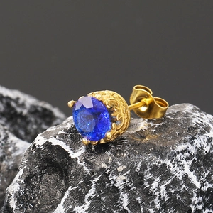 Détail macro d'une boucle d'oreille vintage en or avec un zircon bleu foncé serti couronne