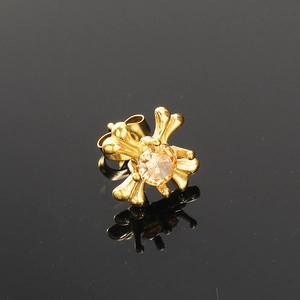 Macro-opname van gouden kruis oorknopjes met fonkelende diamant op zwarte achtergrond