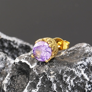 Macro d'une boucle d'oreille rétro en or avec zircon violet et détails gravés