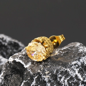 Gros plan d'une boucle d'oreille rétro en or avec zircon champagne sur pierre