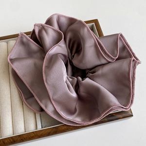 Elegant mauve satin oversized scrunchie with layered pleats on a wooden jewelry tray