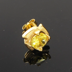 Gros plan détaillé d'une puce d'oreille dorée avec un grand zircon jaune et fermoir papillon