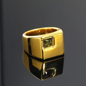 Detalle macro de un anillo de sello dorado con una piedra rectangular verde oscuro