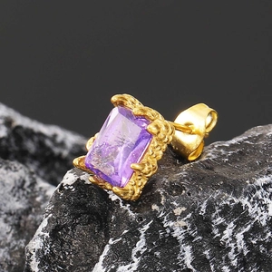Makro-Detail von lila Zirkonia-Ohrring mit goldener Lava-Struktur-Oberfläche