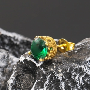 Vue macro d'un clou d'oreille vintage avec une grande pierre précieuse vert émeraude