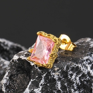 Makroansicht eines rosa Zirkonia-Ohrrings im Quadratschliff mit geprägtem Golddekor