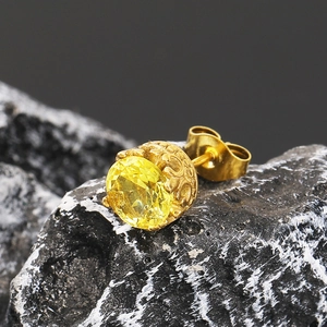 Gros plan détaillé du clou d'oreille zircon jaune avec gravure vintage sur roche