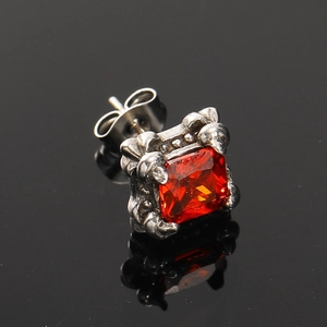 Makroansicht des Vintage-Ohrsteckers aus Silber mit rotem Zirkon und gotischer Gravur