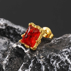 Makroansicht von Vintage-Ohrstecker mit rotem Zirkonia auf schwarzem Felsgestein