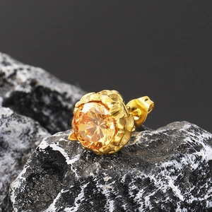 Macro shot of a vintage gold stud earring with a round amber cubic zirconia stone