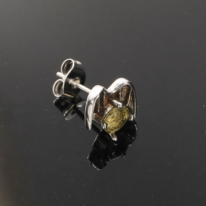 Macro view of punk wing stud earring with green gemstone and vintage silver finish