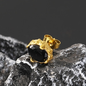 Macro detail of gothic oval black zircon stud earring with vintage textured gold finish