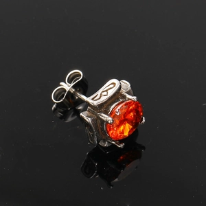 Macro shot of square zirconia titanium steel earring with orange stone and vintage texture