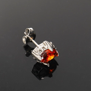 Detailed macro view of punk style oval amber zircon stud earring with vintage relief base