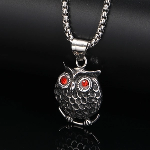 Detailaufnahme der Eulen-Halskette mit roten Edelsteinaugen und silberner Box-Kette