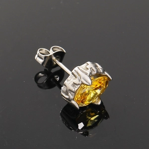 Macro view of titanium steel earring with amber zircon and gothic liquid metal setting