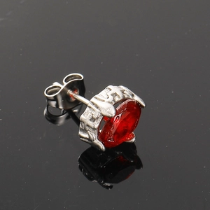 Detailed macro view of oval red zircon earring with vintage silver steel finish