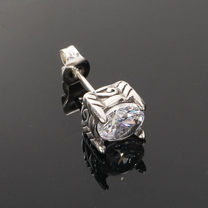 Primer plano de arete de acero inoxidable vintage con circonita y grabado ornamentado