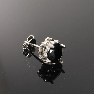 Macro view of vintage silver textured stud earring featuring a faceted black gemstone