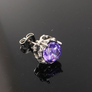 Macro view of purple cubic zirconia stud earring with crown setting and silver base
