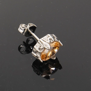 Detail view of silver steel stud earring with cross carving and amber zircon stone