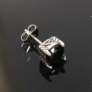 Detalle de pendiente de plata con piedra negra y grabado floral de estilo gótico