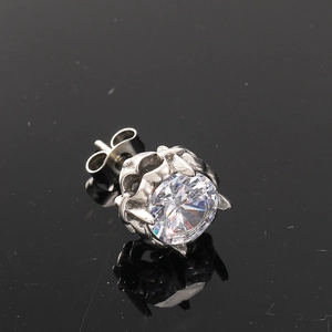 Macro shot of silver titanium stud earring with large diamond in crown claw setting