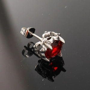 Detail of retro gothic earring with red zircon stone and silver crown claw setting