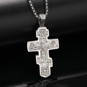 Close-up of Eastern Orthodox cross pendant with vintage silver finish and detailed relief