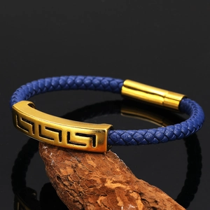 Navy braided leather bracelet with golden Greek Key engraved metal on weathered wood