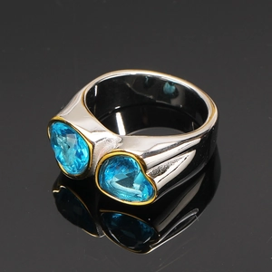 Bague en acier titane avec deux pierres de coeur bleues et sertissage doré élégant