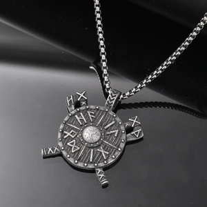 Macro shot of vintage Viking shield pendant with runic engravings and crossed battle axes