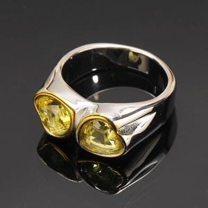 Détail de la bague en titane argenté avec deux zircons jaunes en cœur et bordure dorée