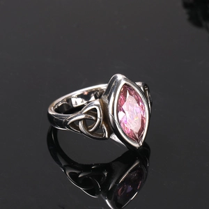 Détail macro d'une bague en acier avec pierre rose marquise et motifs de nœuds celtiques