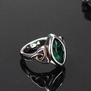 Macro d'une pierre marquise verte sur bague vintage en acier inoxydable avec nœud celtique