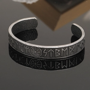 Close-up of vintage silver Viking cuff bracelet with Norse runes and Vegvisir symbol
