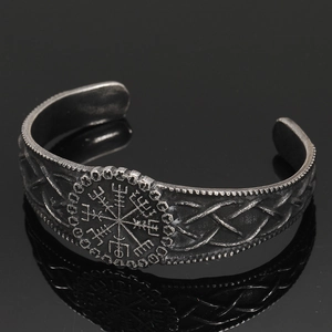 Detailed view of Viking Vegvisir compass and Celtic knot patterns on vintage steel cuff