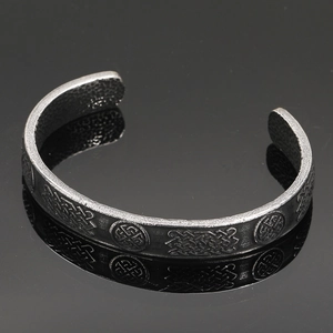 Detailed macro view of vintage Viking stainless steel cuff featuring Celtic knot patterns
