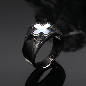 Makroaufnahme eines schwarzen Titanrings mit weißem Perlmutt Kreuz-Inlay im Detail