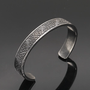 Detailed macro view of vintage Viking cuff bracelet with Celtic knot patterns in steel