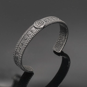 Detail of Viking Valknut symbol and Norse runes on a retro oxidized steel cuff bracelet