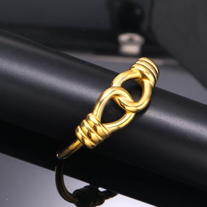 Macro shot of interlocking golden knot bracelet with textured screw detailing