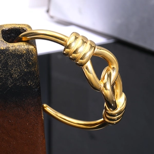 Minimalist gold-plated stainless steel knot cuff bracelet with a polished mirror finish