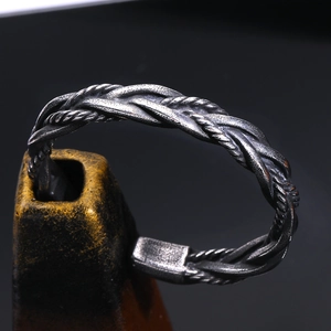 Vue macro du design tressé vintage sur un bracelet jonc en acier titane pour homme