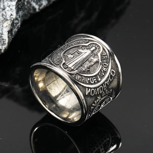 Macro shot of vintage St. Benedict medal ring with religious relief and steel finish