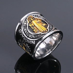 Macro detail of retro Saint Benedict medal ring in steel with embossed gold saint icon