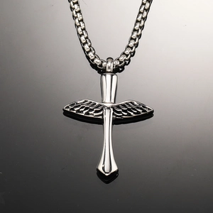 Detailed macro view of silver cross and wing pendant on a polished steel chain